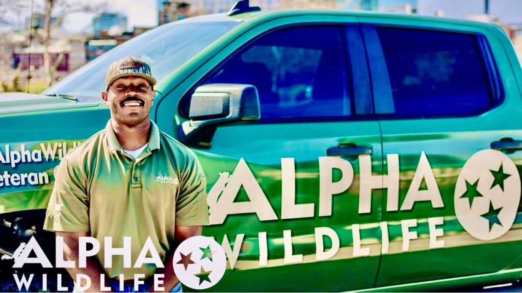 Alpha Wildlife Technician standing next to his truck